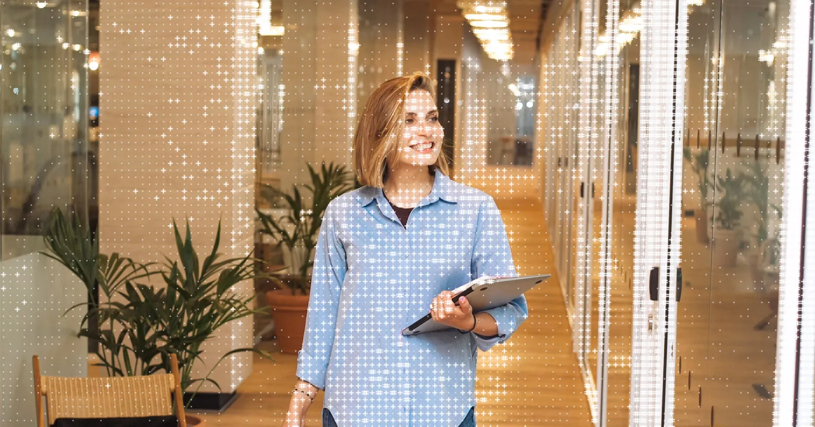 A woman walking through a bright office hallway, a field of dots overlaid